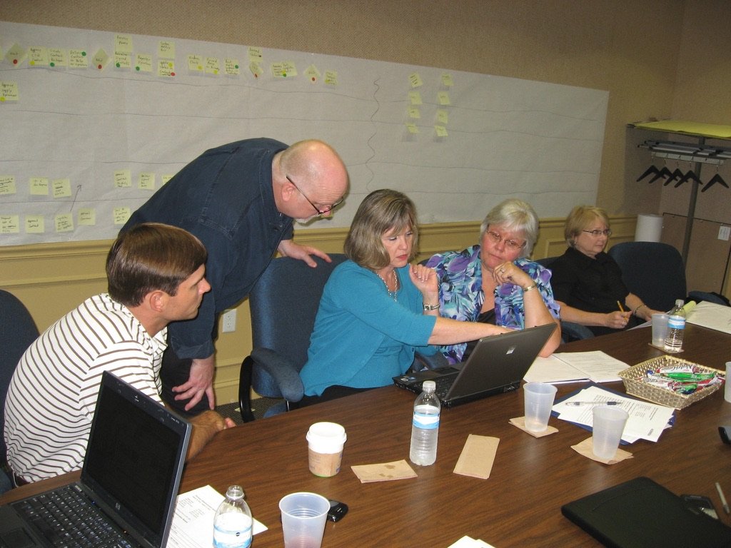 Working shoulder to shoulder: coaching a team member through a system at her laptop