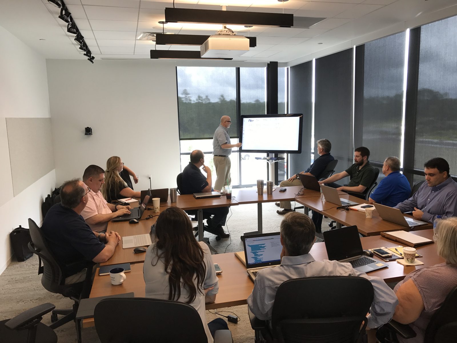 A facilitator sketching a data model on a digital whiteboard while the team looks on
